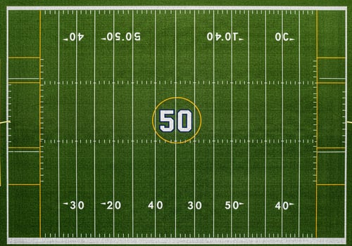 An aerial view of a football field with yard lines and markings photo
