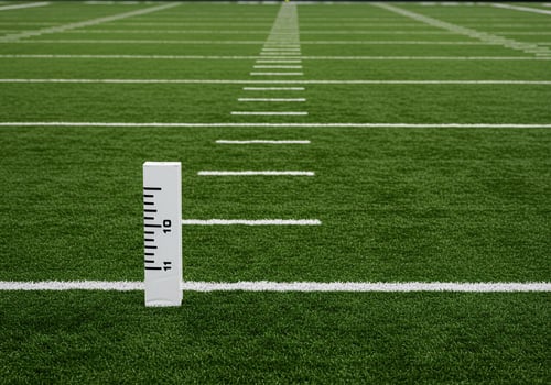 Closeup of a football field showing yard lines and a marker photo
