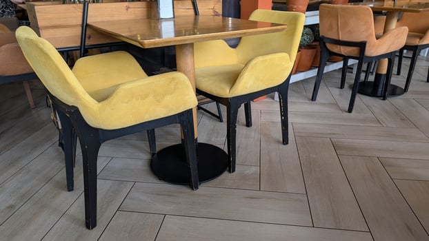 The Stylish Cafe has Modern Yellow Chairs and Wooden Tables for an inviting vibe photo