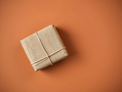 Rustic Burlap Gift Box on Ochre Background Minimalist Packaging Design photo