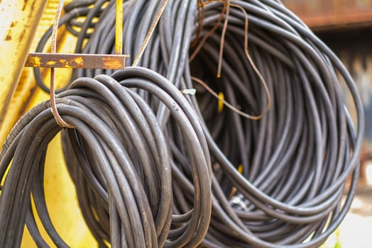 Moscow, Russia, 18.06.2025 Coiled electrical wire attached to a metal bar. Industrial cable for power transmission and construction site use. photo