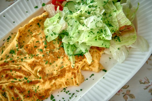 Deliciously Light and Flavorful Omelet Served with Fresh Herb Garnish and Crisp Salad Alongside for a Wholesome Meal Experience photo