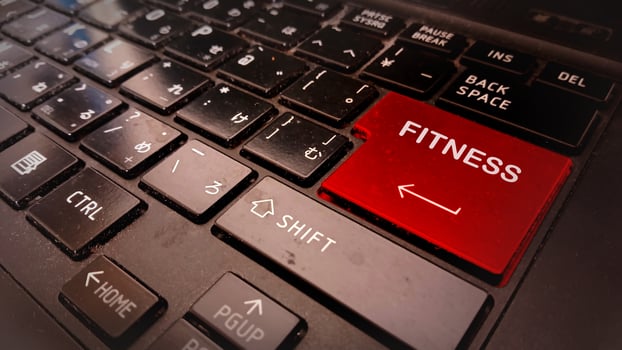 A red fitness button is on a laptop keyboard photo