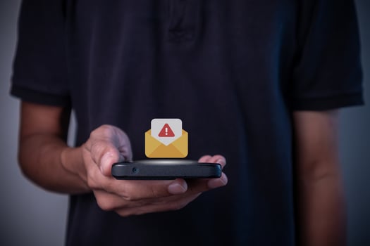 A man holding smartphone with message or email notification with warning symbol photo