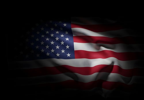 An american flag is shown in the black background photo