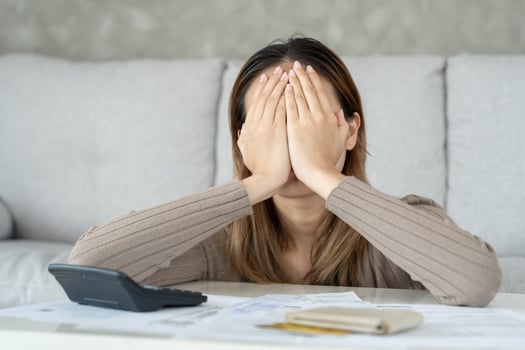Stressed headache asian woman with large bills or invoices no money to pay to expenses and credit card debt. shortage, Financial problems, mortgage, loan, bankruptcy, bankrupt, poor, empty wallet photo