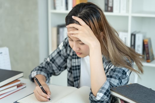 Asian student woman have anxiety because of exams, female prepare for test and learning lessons in the library. stress, despair, haste, misunderstanding reading, discouraged, expectation,. knowledge. photo