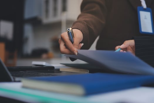 A person in a suit holding a pen and paper photo