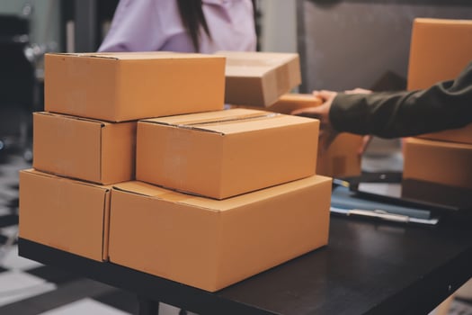 A man and woman are packing boxes on a table photo