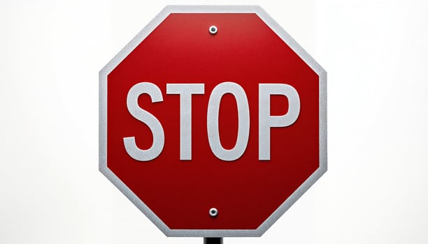 A red octagonal STOP sign stands prominently against a white background. photo