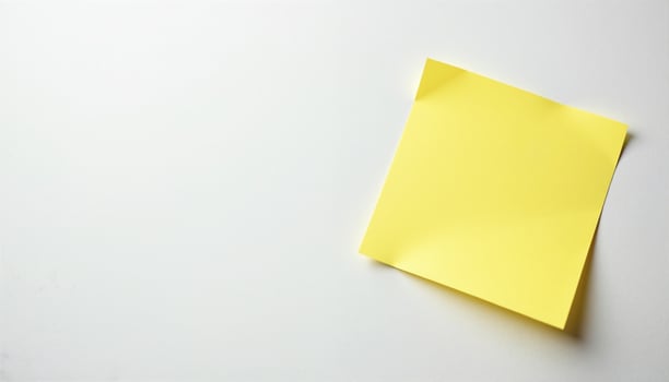A solitary yellow sticky note on a pristine white surface. photo