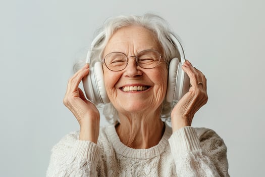 Joyful elderly woman wearing headphones and smiling brightly, isolated on white background. Ideal for concepts of happiness, active aging, modern lifestyle and audio entertainment photo