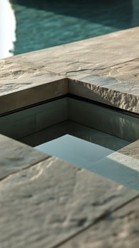 Modern Pool Design With a Stylish Water Feature and Stone Surround photo