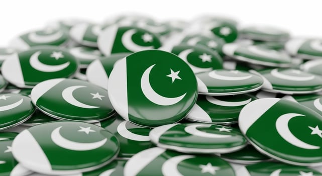 A large pile of glossy round badges featuring the green and white national flag of Pakistan. photo