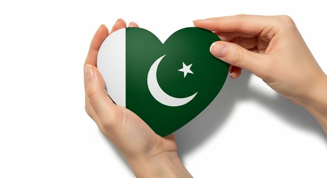 Hands gently holding a heartshaped Pakistan flag against a white background. photo