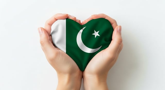 Heartshaped Pakistan Flag Held in Hands on White Background. photo