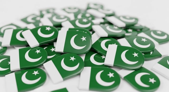 Pile of Pakistan Flags with Crescent Moon and Star Symbols. photo