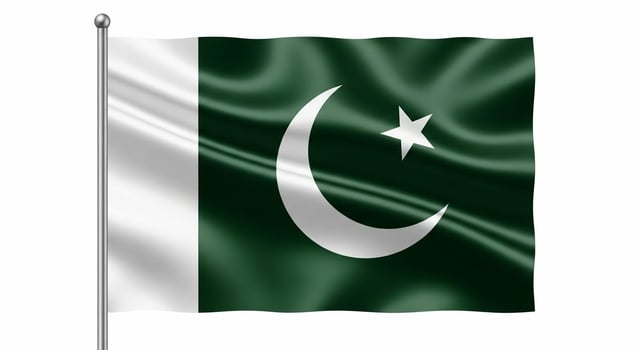 Waving flag of Pakistan with crescent and star on a flagpole isolated on a white background. photo