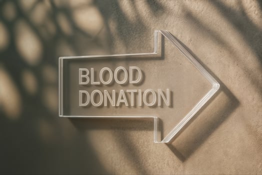 Blood Donation Signage with Transparent 3D Arrow on Textured Wall Surface Featuring Natural Shadows photo