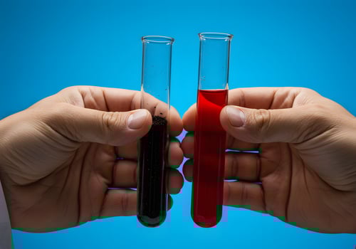 Two hands holding test tubes with red liquid photo