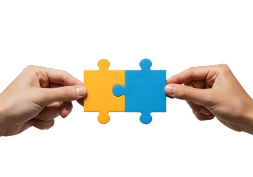 Two hands holding a puzzle piece with two pieces of blue and yellow photo