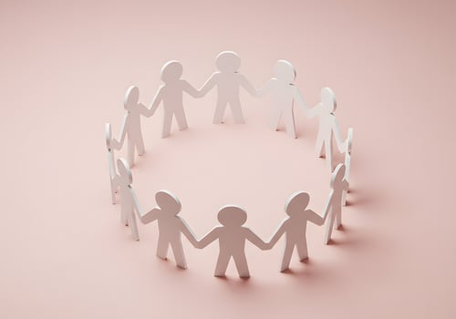 White paper people standing in a circle on a pink background photo