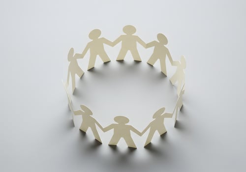 Paper cutout people holding hands in a circle photo