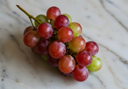 A bunch of grapes sitting on a marble surface photo