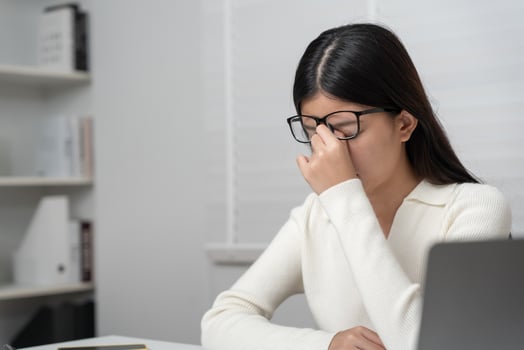 Eye problem,. Asian women with tired and irritated eyes, eye rubbing, dry, eye pain after work, migraine, headache, blurred vision, photophobia, working in the dark, blue light from computer photo
