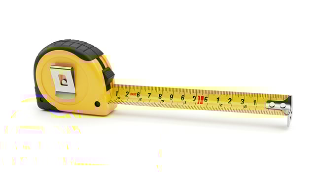 Yellow Tape Measure with Black Grip and Silver Metal End on White Background photo