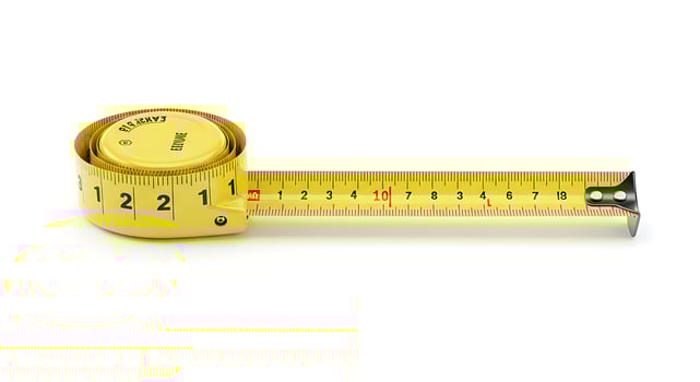Yellow Measuring Tape Rolled and Extended on White Background for Construction and Sewing photo