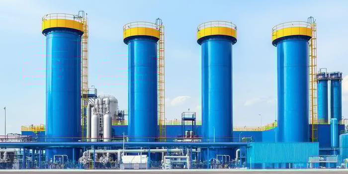 Blue industrial storage tanks against a bright sky, modern facility. photo