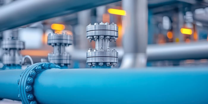 Close-up of industrial piping system with valves and bright lights. photo