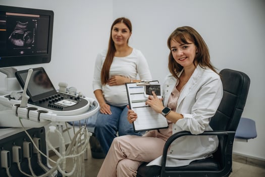 A woman is holding a clipboard while sitting in front of a computer photo