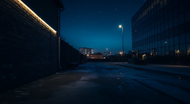 Nighttime Urban Street Scene with Modern Buildings and Streetlights in Clear Sky photo