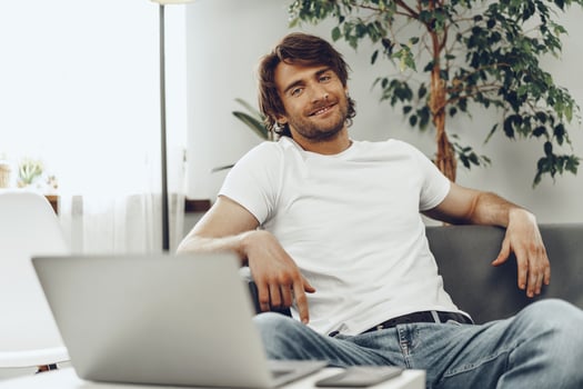 Relaxed casual man sitting on the sofa and looking at camera photo