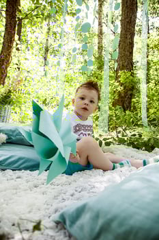 khabarovsk, russia,28.08.2013. A young child is sitting on a blanket in a forest, holding a paper fan photo