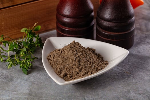 A bowl of spices and a bottle of sauce photo