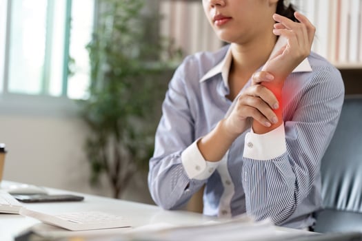 Office Syndrome. Woman Holding Her Wrist in Pain While Working photo