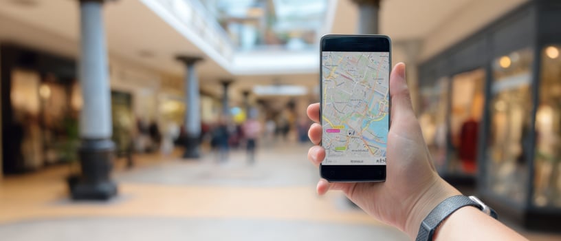 The smartphone displays a map for navigation in a bustling shopping mall. photo