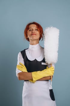 A woman in a maid outfit holding a mop photo