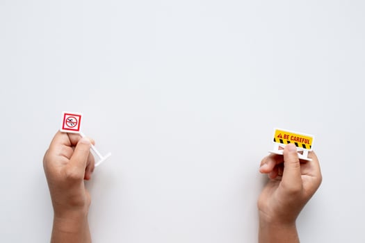 Hands holding mini caution signs on white background photo