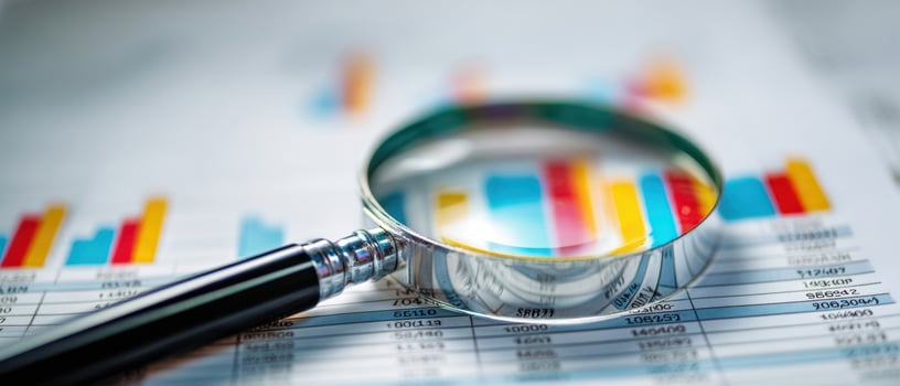 The magnifying glass highlighting important data on financial performance graphs. photo