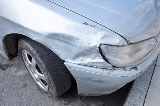 A Dented Fender on a Silver Car After an Accident. Concept Car insurance claim. photo