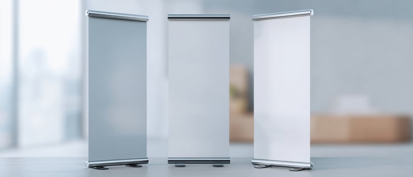 The three minimalist roll-up banners in a modern office setting. photo