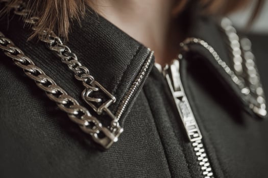 A woman wearing a black jacket with chains photo