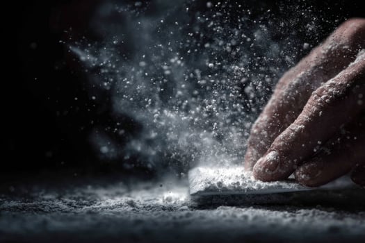 A person is sprinkling flour on a table photo