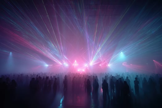 A crowd of people standing in front of a stage with colorful lights photo