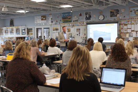 A man giving a presentation to a classroom full of people photo