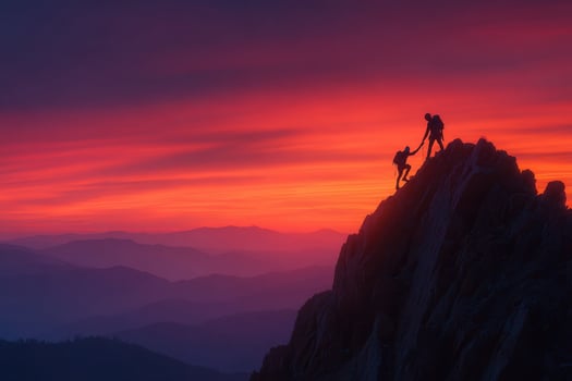 Two people standing on top of a mountain at sunset photo